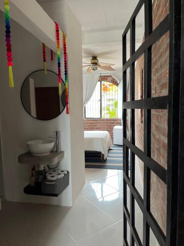 een badkamer met een spiegel en een bakstenen muur bij Casa Estrella in Puerto Vallarta