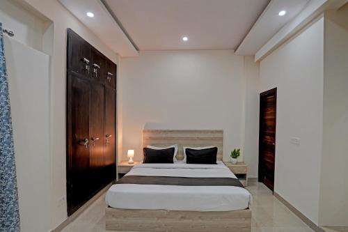 ein Schlafzimmer mit einem großen Bett und einem Holzschrank in der Unterkunft OYO Hotel Sunrise in Noida