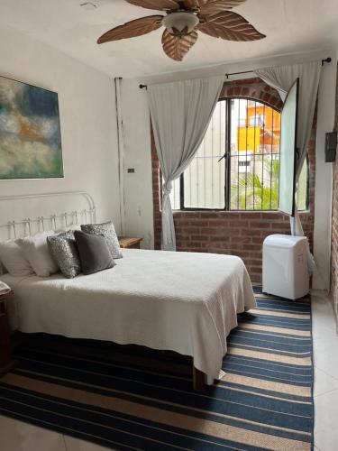 1 dormitorio con 1 cama y ventilador de techo en Casa Estrella, en Puerto Vallarta