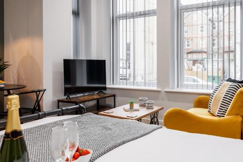 a living room with a bed and a tv at Sea Breeze - Coast in Bournemouth