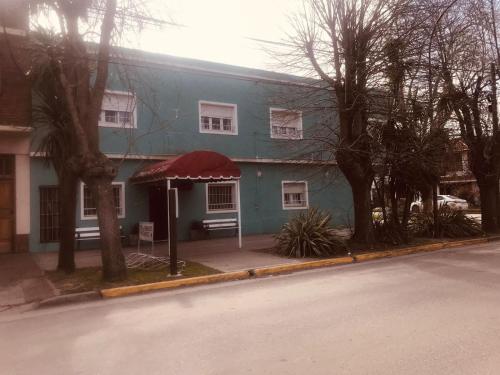 a blue house with a red awning on a street at Hotel Embassy in Miramar