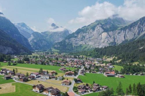 a village in a valley with mountains in the background at Chalet Spatz Garden near Oeschinen Lake in Kandersteg