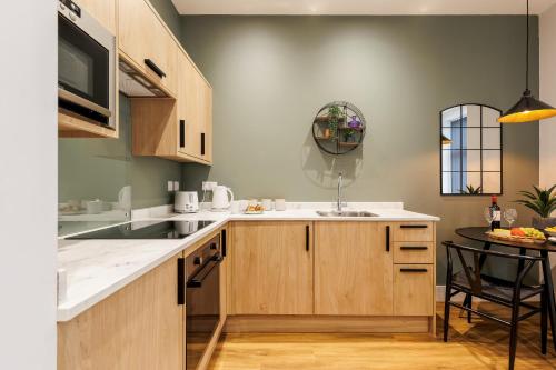 a kitchen with wooden cabinets and a sink and a table at Sea Breeze - Coast in Bournemouth