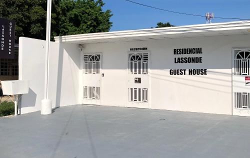 a white building with doors and a guest house at Residencial Lassonde Guest House in David