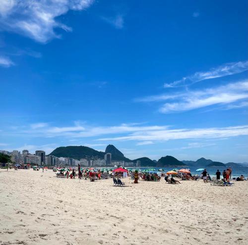 a group of people on a beach with umbrellas at Beira Mar Copa in Rio de Janeiro