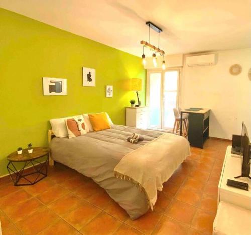 - un grand lit dans une chambre dotée d'un mur vert dans l'établissement Studio de la gare, à Aix-en-Provence
