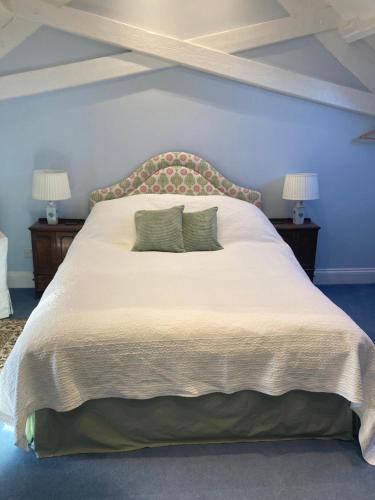 a bedroom with a large bed with two lamps at The Old Post Office B&B in Longwitton