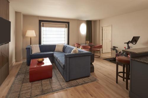 a living room with a blue couch and a table at Hotel Vesper, Houston, a Tribute Portfolio Hotel in Houston