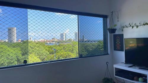 um quarto com uma grande janela com vista para a cidade em Seu lugar no Carnaval do Recife! no Recife