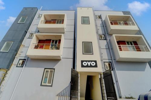 a white building with a yes sign on it at Mm Home Stays in Irugūr