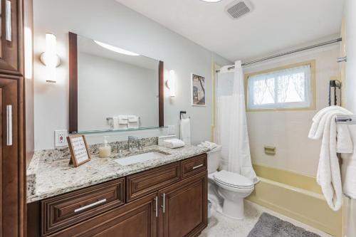 a bathroom with a sink and a toilet and a mirror at Riverside Retreat: Deck Bar, FirePit, Boat Parking in Fort Myers