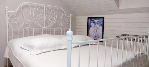 una culla bianca in una camera bianca con un letto di KLARA Vracar a Belgrado