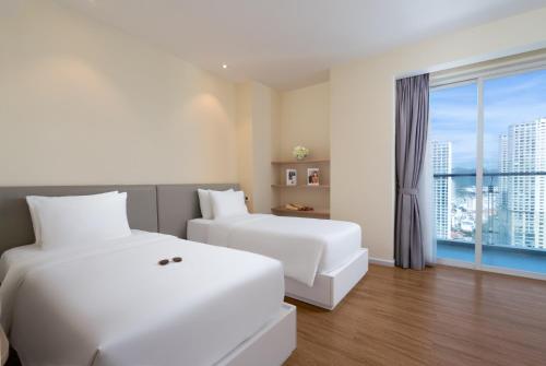a hotel room with two beds and a window at TUI BLUE Nha Trang in Nha Trang