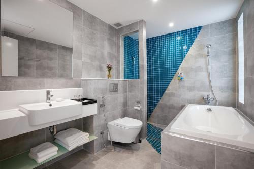 a bathroom with a sink and a tub and a toilet at TUI BLUE Nha Trang in Nha Trang