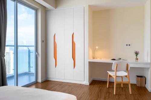 a bedroom with a bed and a desk and a chair at TUI BLUE Nha Trang in Nha Trang