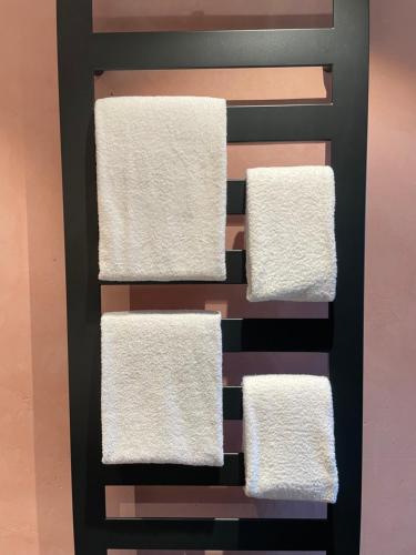 four towels on a rack in a bathroom at Moderne Ferienwohnung mit Zugspitzblick in Grainau