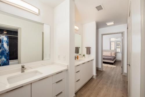 a white bathroom with two sinks and a mirror at Uptown's Elite- 4BR Luxury Oasis in Charlotte