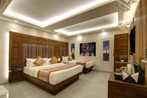 a hotel room with two beds and a television at BLESS INN - Near Connaugt Place in New Delhi