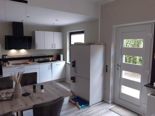 a kitchen with a white refrigerator and a table at FEWO Happe in Lennestadt