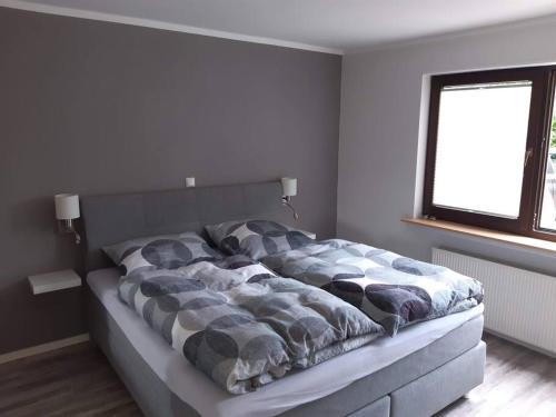 a large bed in a room with a window at FEWO Happe in Lennestadt