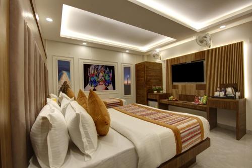 a bedroom with a large bed and a television at BLESS INN - Near Connaught Place in New Delhi