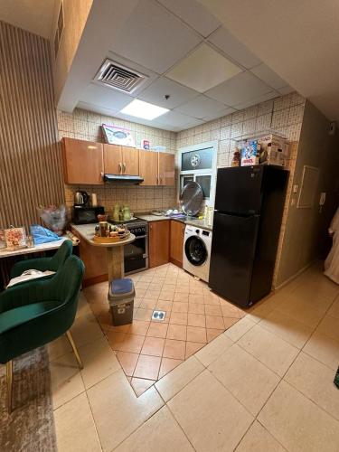 a kitchen with a black refrigerator and a washer at dubai silicon oasis in Dubai