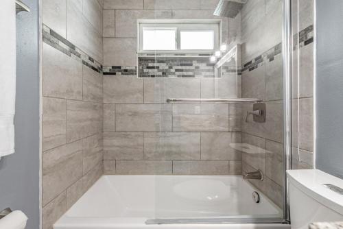 a white bathroom with a tub and a window at Ocean Blue Heated Pool Home in Largo