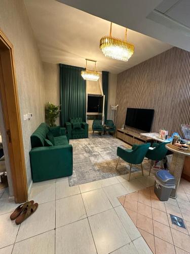 een woonkamer met een groene bank en stoelen bij dubai silicon oasis in Dubai