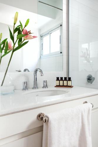 a white bathroom with a sink and a mirror at Casa Bevant Hotel Boutique in Buenos Aires