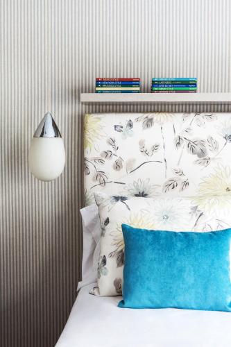 a bedroom with a bed with a blue pillow at Casa Bevant Hotel Boutique in Buenos Aires