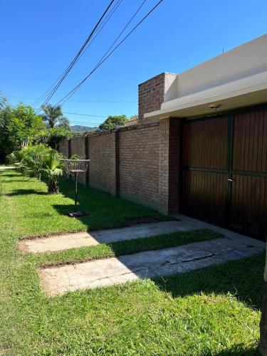 a brick house with a fence and a garage at PATASTAY in San Salvador de Jujuy