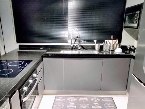 a kitchen with a sink and a large window at Casa inteira l 7 min Alphaville in Osasco