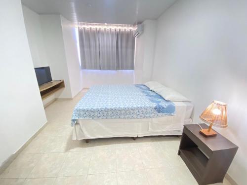 a white bedroom with a bed and a window at Moriah Maceió Beach Hotel in Maceió