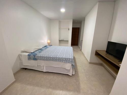 a bedroom with a bed and a flat screen tv at Moriah Maceió Beach Hotel in Maceió