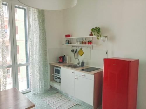 a kitchen with a red refrigerator next to a window at La casa di Alessandro in Monopoli