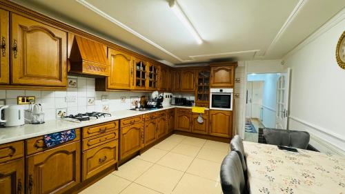 a kitchen with wooden cabinets and a table and a counter top at Double room in Greater London (Hackney) in London