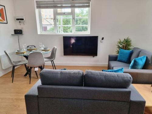 a living room with a couch and a table at 2 bedroom central apartment near station in London