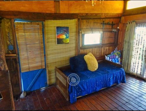 a bedroom with a blue bed in a cabin at Casita de Mar in Cabo Polonio