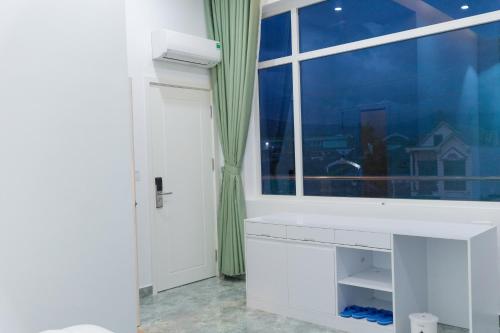 uma casa de banho com um lavatório branco e uma janela em Khách Sạn Vinci em Namban