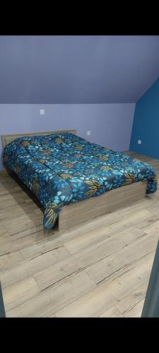 a bed with a colorful comforter in a bedroom at La Clé du Bonheur in Friville-Escarbotin