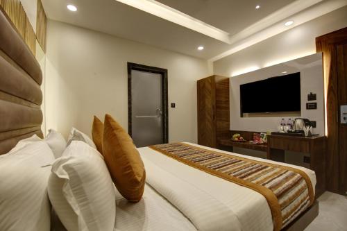a hotel room with a bed and a television at BLESS INN - Near Connaught Place in New Delhi