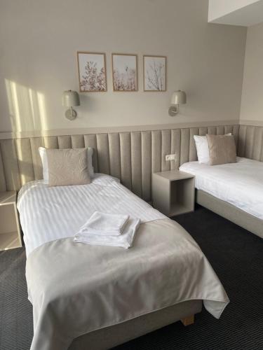 a hotel room with two beds with towels on it at Apartamenty Wolności 6 self check-in 24h in Poznań