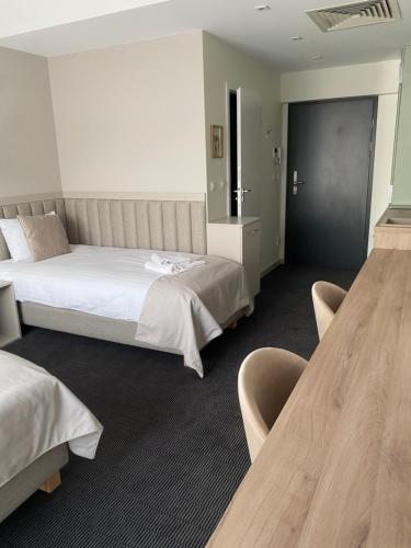a hotel room with two beds and two tables at Apartamenty Wolności 6 self check-in 24h in Poznań