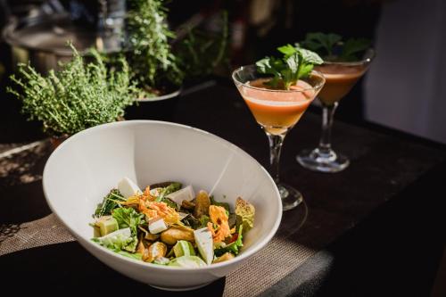 a bowl of salad on a table with two drinks at Casagrande Sunset II - Fuerteventura - Costa Calma in Pájara