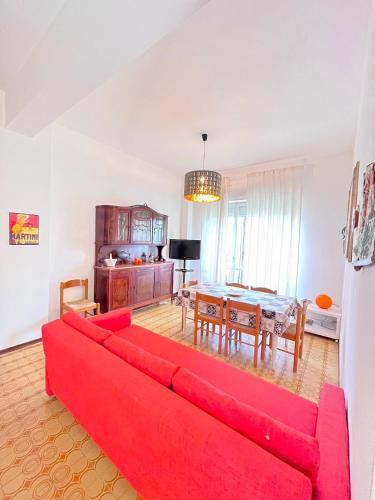 a living room with a red couch and a table at Trilo Stefano in residence con piscina, vicino al mare in Marcelli