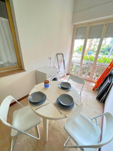 a table and chairs in a room with a window at Trilo Stefano in residence con piscina, vicino al mare in Marcelli
