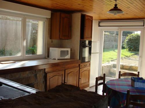 - une cuisine avec un comptoir, un four micro-ondes et une table dans l'établissement MAISON SUR TERRAIN CLOS MER IROISE, à Plouarzel