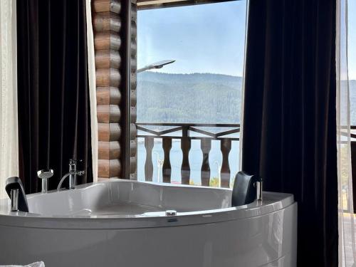 a bath tub in a room with a large window at Villa ART in Dospat