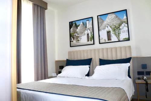 a bedroom with a bed with three pictures on the wall at Vittoria Parc Hotel in Bari