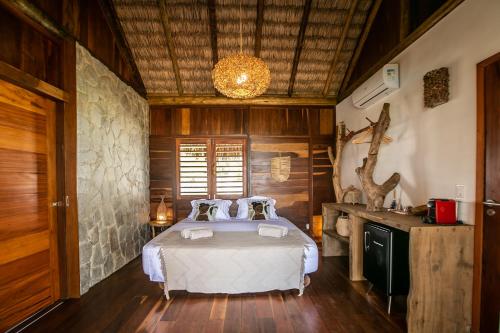 a bedroom with a bed in a room with wooden walls at Rancho Noé Cumbuco in Cumbuco
